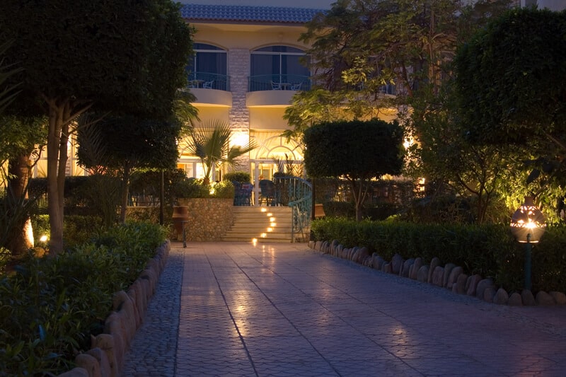 Picture of a modern hotel at the night time with beautiful garden on the front area.