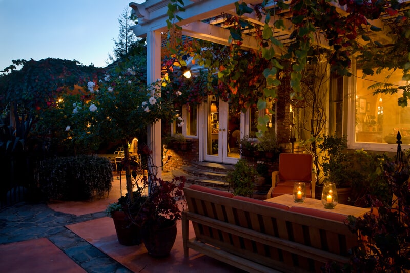 Luxurious house patio seating area seen illuminated at night.
